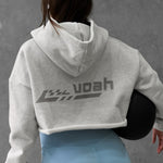 Person wearing a gray hoodie with 'voah' branding and light blue shorts against a gray background